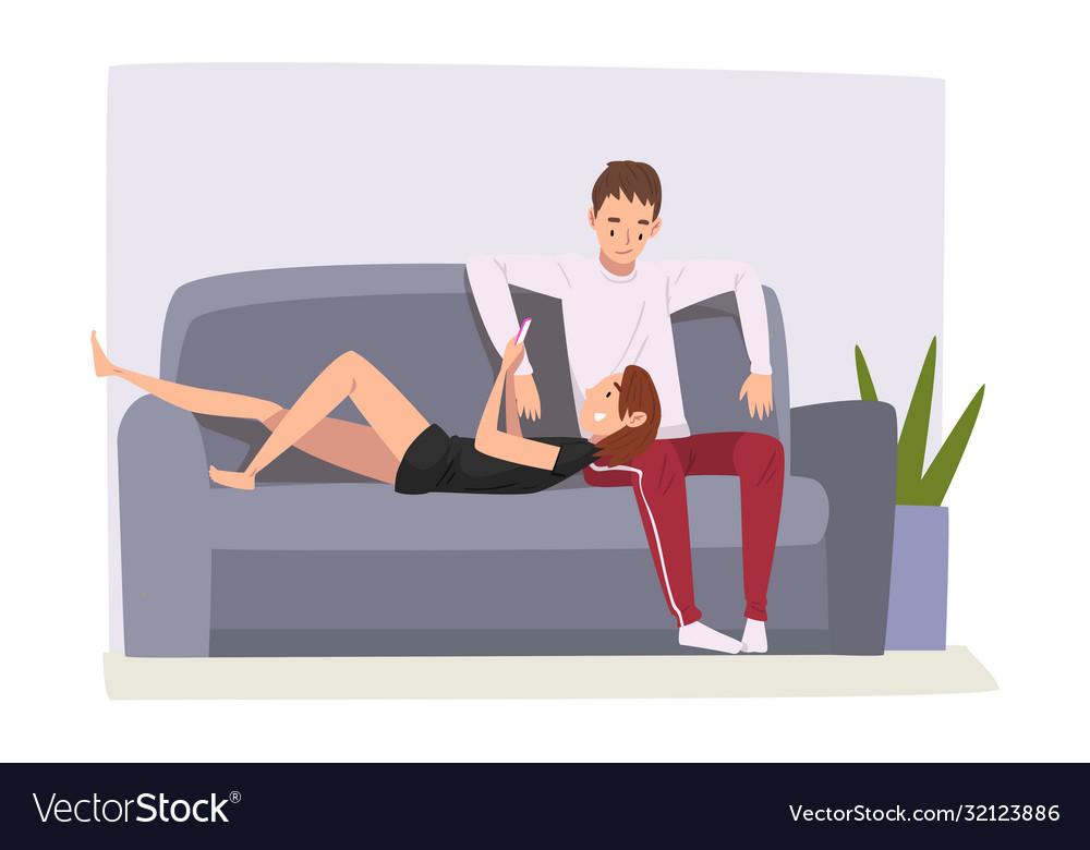 Cheerful couple sitting on sofa at home male