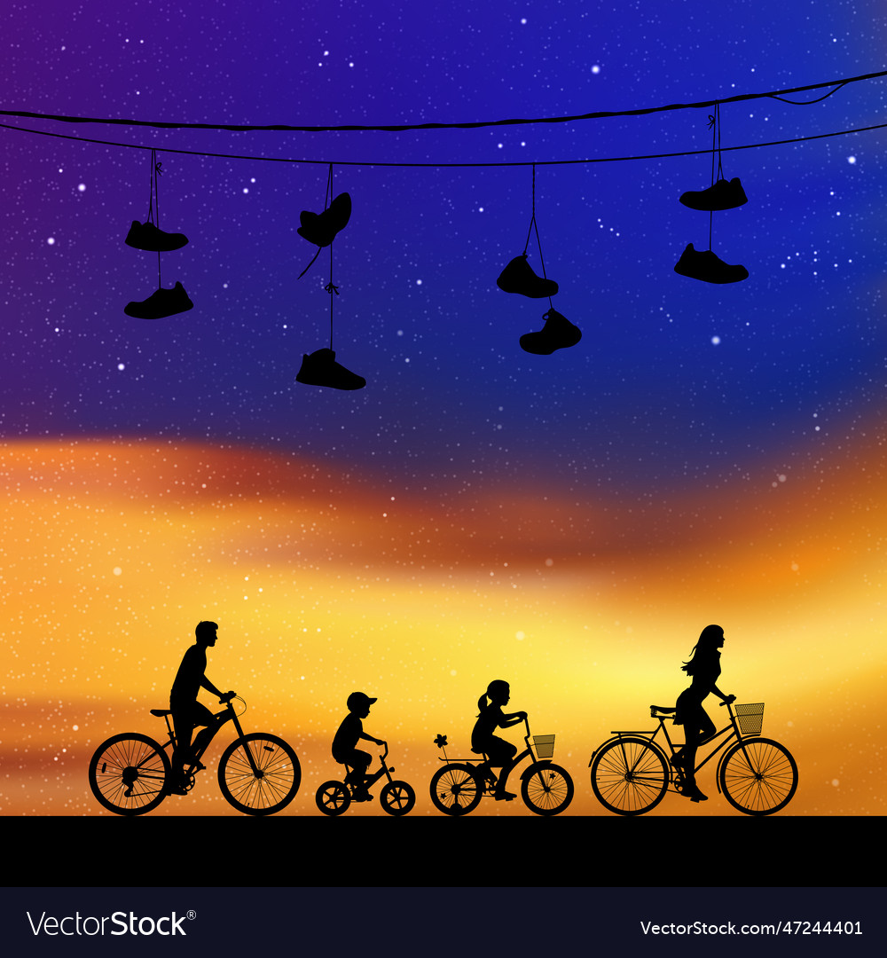 Family on bikes under shoes wires at night