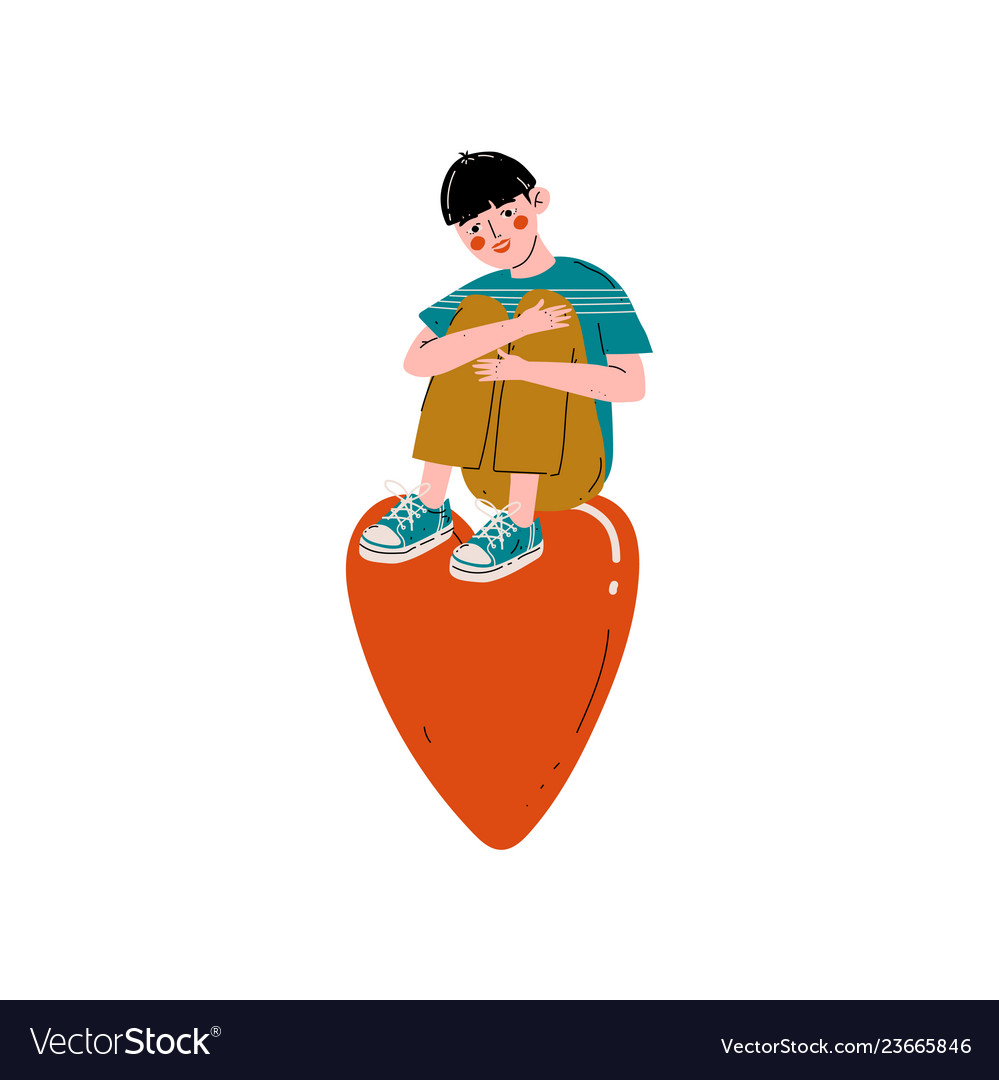 Teen boy sitting on a huge red heart happy