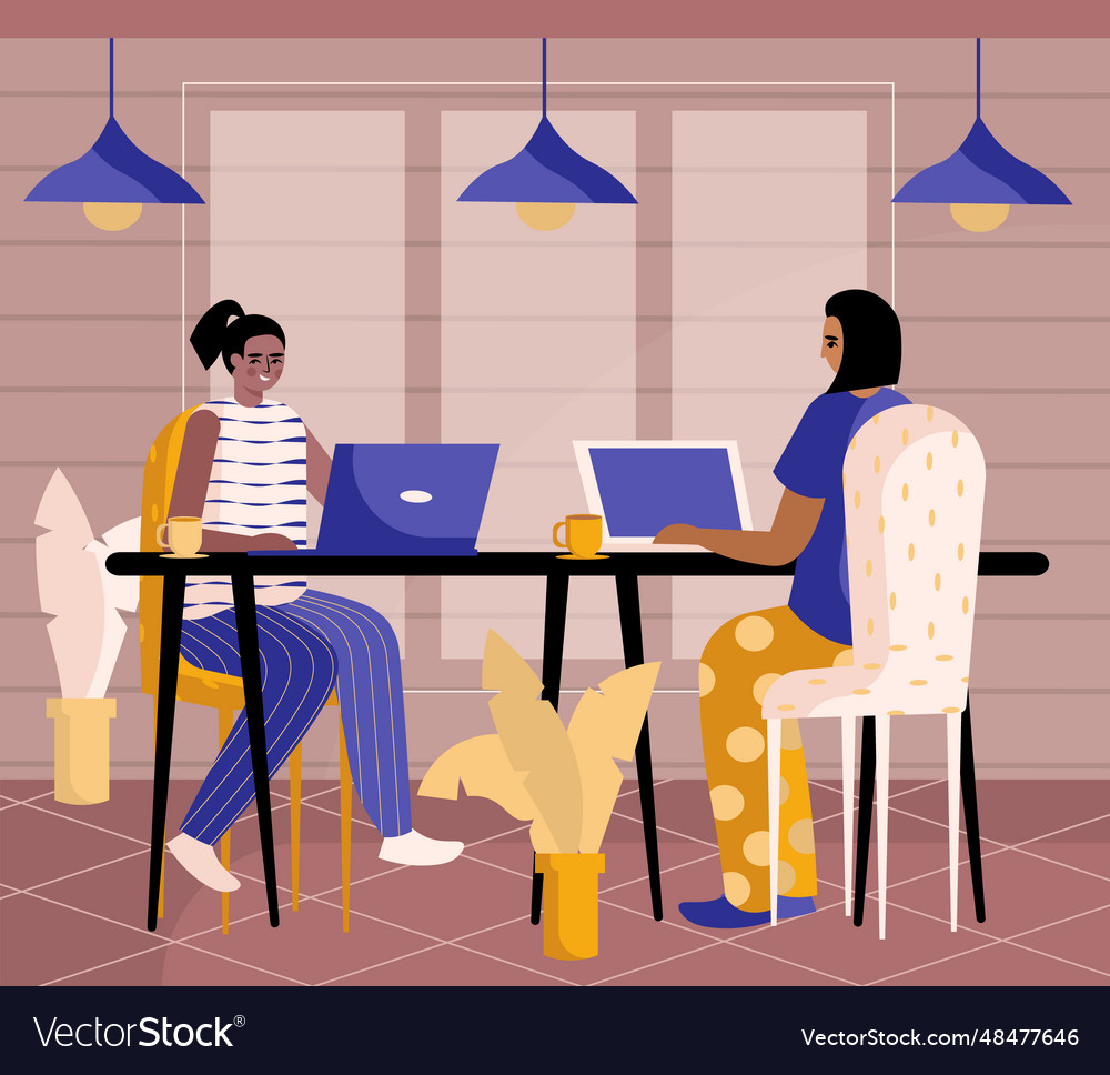 Smiling women sitting at table working on laptop