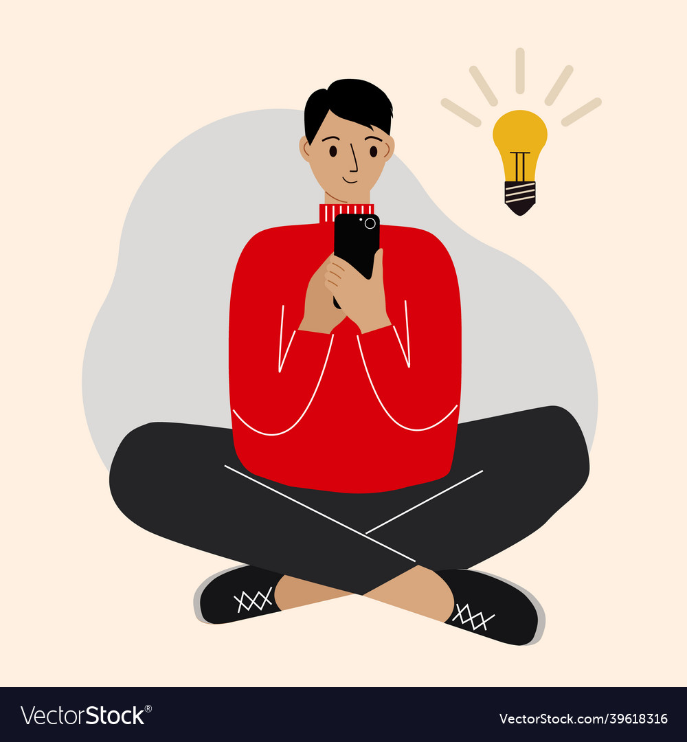 Young man using phone sitting cross-legged