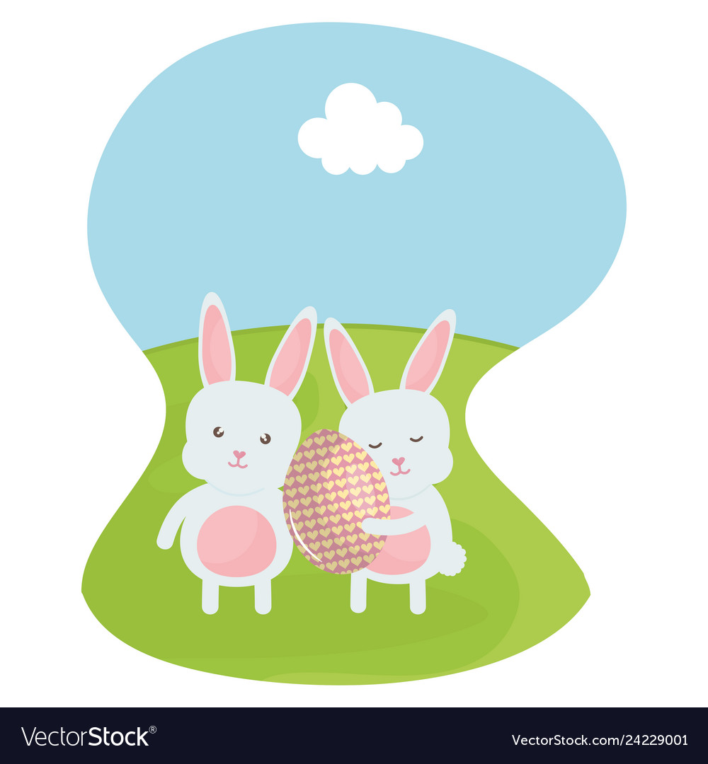 Cute rabbits with easter egg painted in the field