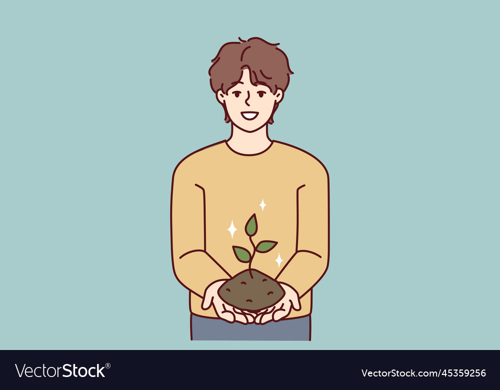 Smiling teenage boy holding earth with growing