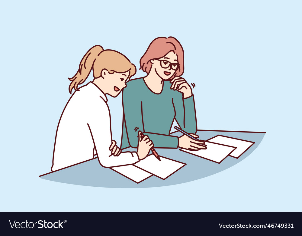 Women doing paperwork sitting at table in office