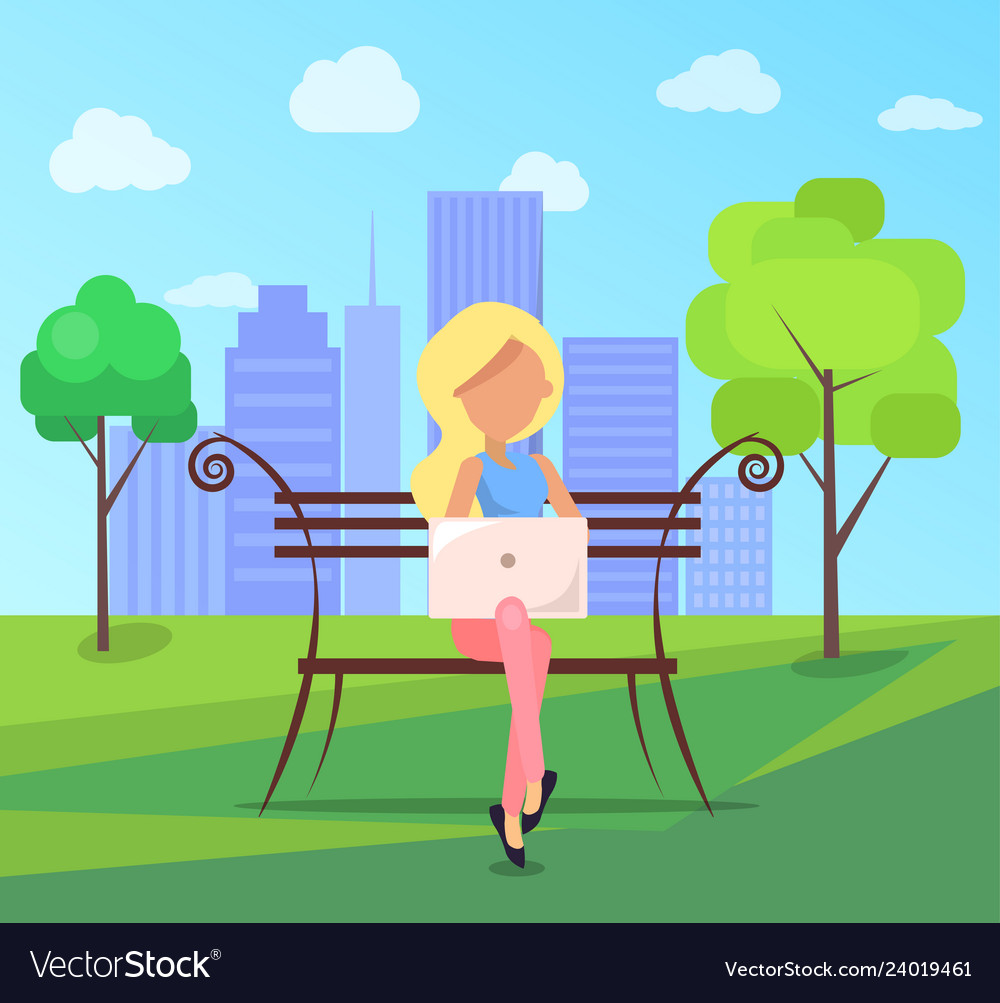 Woman sits on bench in city park with laptop