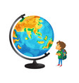 boy with schoolbag looks at big globe vector image